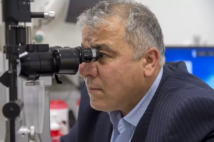 An Optegra Specialist Using A Microscope